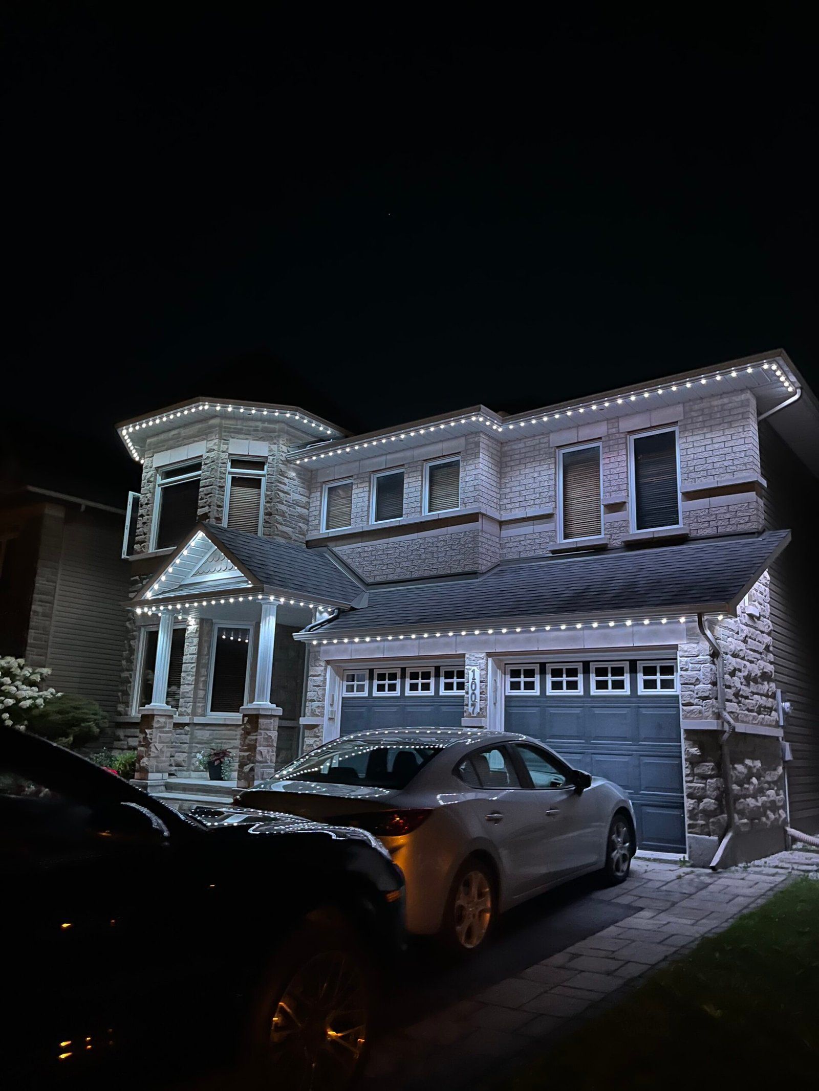 Two-storey Ottawa home with permanent white LED lights along every roofline at night