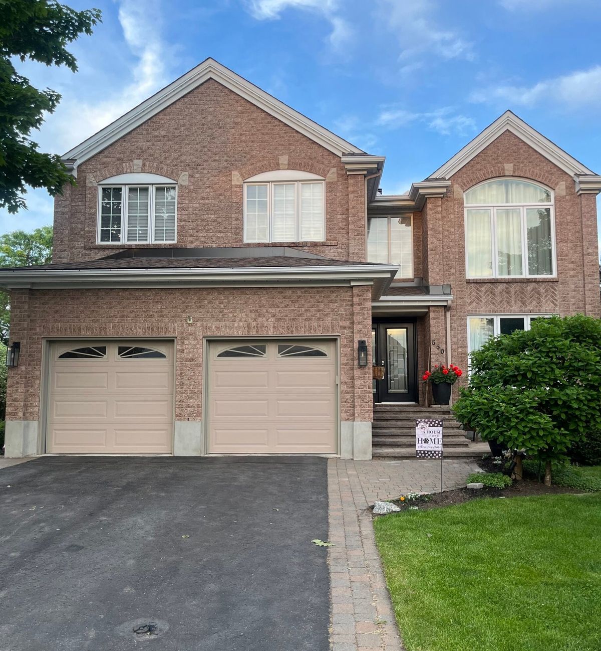 Brick Ottawa home in daylight; the lighting track under the roofline is hard to see